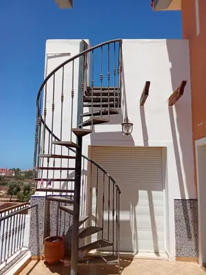 a staircase on the side of a building with a garage at appartement duplex a saidia in Oulad Akkou