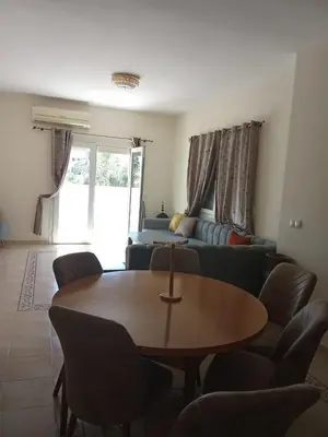 a living room with a table and a couch at appartement duplex a saidia in Oulad Akkou