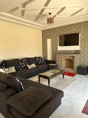 a living room with a couch and a fireplace at villas par jour in Amezrou