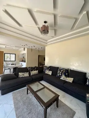 a living room with a couch and a table at villas par jour in Amezrou
