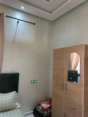 a bedroom with a cupboard and a mirror at villas par jour in Amezrou