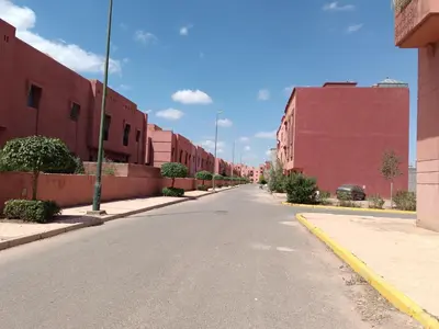 an empty street with red buildings on either side at Chwiter Marrakech in Chouiter
