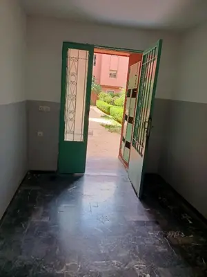 an empty room with a green door and a hallway at Chwiter Marrakech in Chouiter