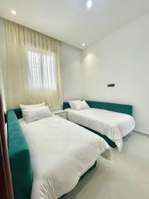 a room with two beds and a window at The White House Tetouan in Oulad Akkou