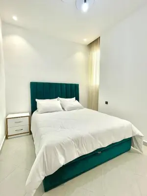 a bedroom with a large bed with a blue headboard at The White House Tetouan in Oulad Akkou