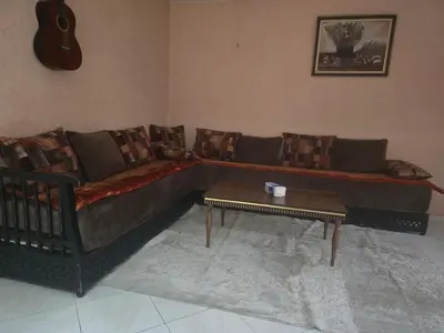 a living room with a couch and a coffee table at Appartement spacieux au cœur de Hamria in Meknès