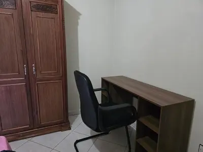 a black chair sitting next to a wooden desk at Appartement spacieux au cœur de Hamria in Meknès