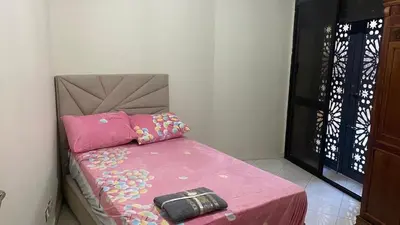 a bed with a pink blanket and a purse on it at Appartement spacieux au cœur de Hamria in Meknès