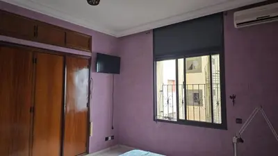 a bedroom with purple walls and a window at Appartement spacieux au cœur de Hamria in Meknès