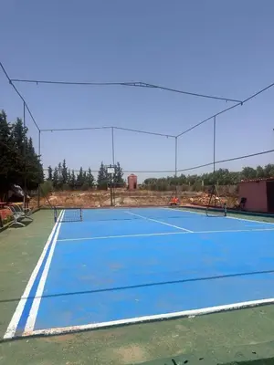 an empty tennis court with a tennis court at Gîte à la ferme khemissat
