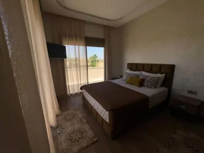 a bedroom with a bed and a large window at villas d'or in Marrakech