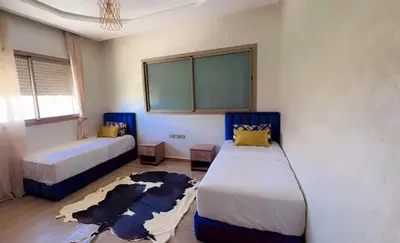 a bedroom with two beds and a rug at villas d'or in Marrakech