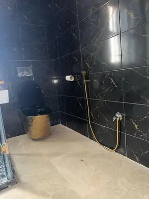 a bathroom with a black tiled wall with a toilet at villas d'or in Marrakech