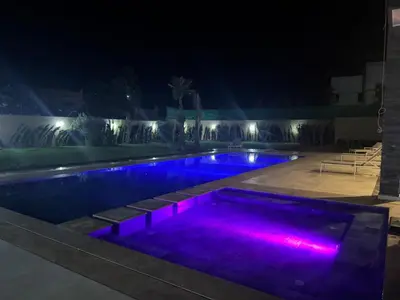 a swimming pool at night with purple lights at villas d'or in Marrakech