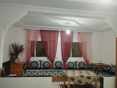 a living room with red curtains and a couch at Super appartement quartier paisible proches toutes commodités in Azrou