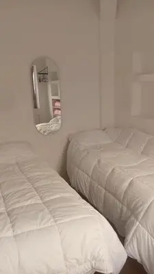 two beds in a white room with a mirror at Á 800m de la Marina Bay Tanger in Oulad Akkou