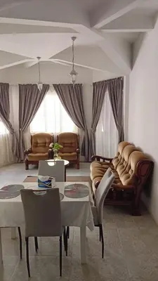 a living room with couches and a table and chairs at Á 800m de la Marina Bay Tanger in Oulad Akkou