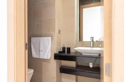 a bathroom with a sink and a mirror at Modern 3BR with High Amenities and Stylish Decor in Oulad Akkou