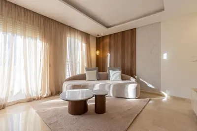 a bedroom with a white bed and a table at Modern 3BR with High Amenities and Stylish Decor in Oulad Akkou