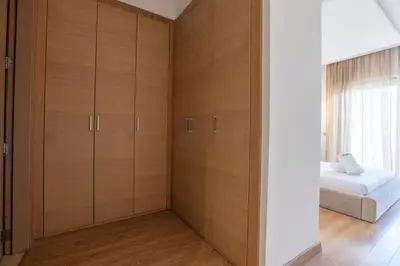a bedroom with wooden cabinets and a bed at Modern 3BR with High Amenities and Stylish Decor in Oulad Akkou