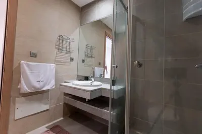 a bathroom with a sink and a shower at Modern 3BR with High Amenities and Stylish Decor in Oulad Akkou