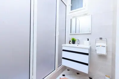 a white bathroom with a sink and a mirror at Modern Elegance 2BR in the Heart of Agdal in Oulad Akkou
