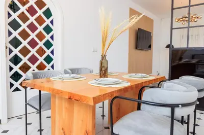 a dining room with a wooden table and chairs at Modern Elegance 2BR in the Heart of Agdal in Oulad Akkou