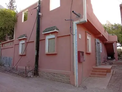 a pink house with stairs and a window at auberge djebel rose 03 in Oulad Akkou