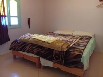 a large bed in a room with a window at auberge djebel rose 03 in Oulad Akkou