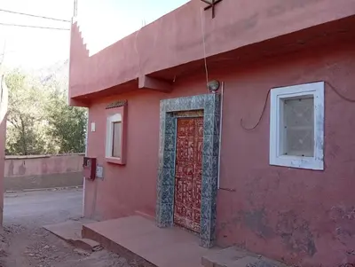 a red building with a red door and a window at auberge djebel rose 03 in Oulad Akkou