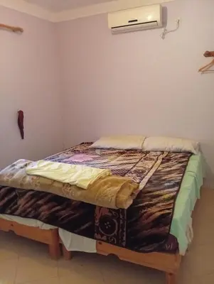 a bed in the corner of a room at auberge djebel rose 03 in Oulad Akkou