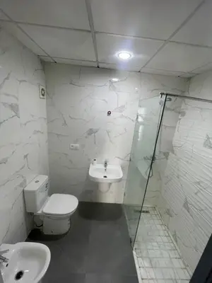 a bathroom with a toilet and a sink and a shower at Modern Pool-View Luxury Flat in Oulad Akkou