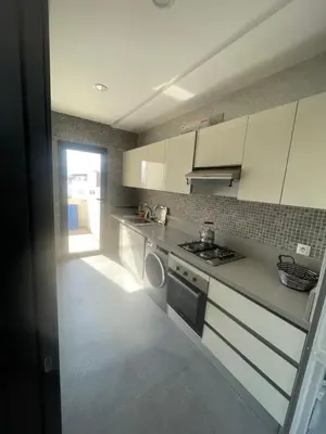 a kitchen with white cabinets and a stove top oven at Modern Pool-View Luxury Flat in Oulad Akkou