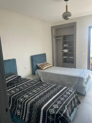 two beds sitting next to each other in a bedroom at Modern Pool-View Luxury Flat in Oulad Akkou