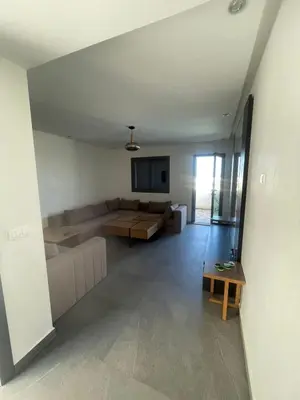 a living room with a couch and a table at Modern Pool-View Luxury Flat in Oulad Akkou