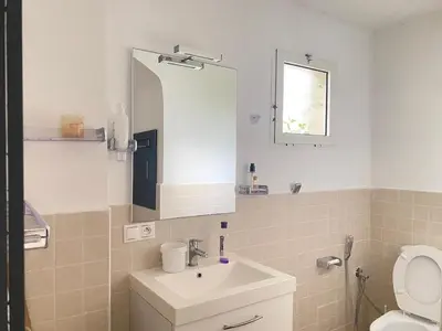 a bathroom with a sink and a toilet and a mirror at Seaside Villa with Stunning View in Oulad Akkou