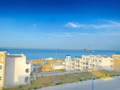 a group of buildings with the ocean in the background at Seaside Villa with Stunning View in Oulad Akkou