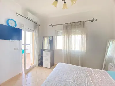 a white bedroom with a bed and a window at Seaside Villa with Stunning View in Oulad Akkou