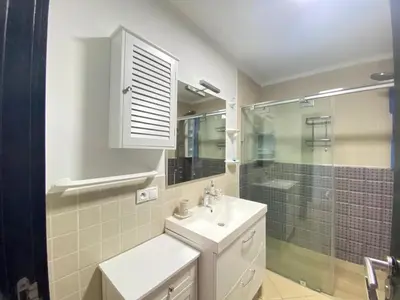 a bathroom with a sink and a shower and a mirror at Seaside Villa with Stunning View in Oulad Akkou