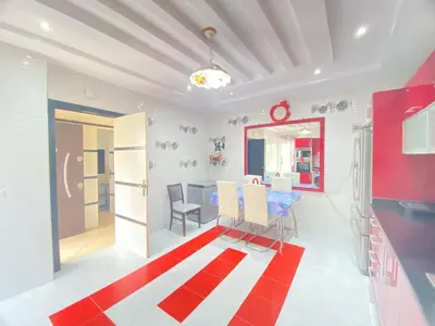 a dining room with a table and a red and white rug at Seaside Villa with Stunning View in Oulad Akkou