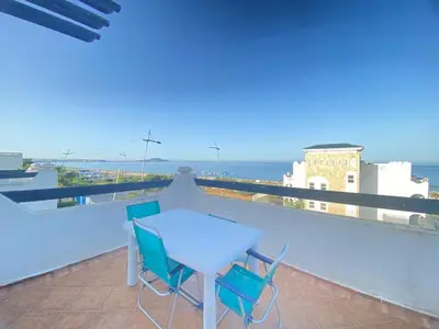 a table and chairs on a balcony with the ocean at Seaside Villa with Stunning View in Oulad Akkou