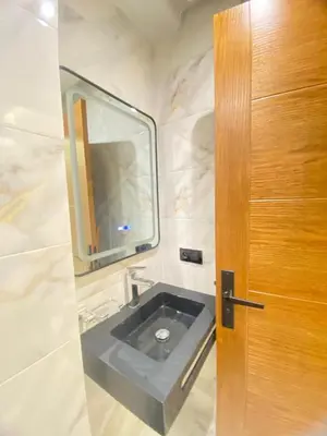 a bathroom with a sink and a wooden door at Modern Equipped Central Suite terassa 8 in Oulad Akkou