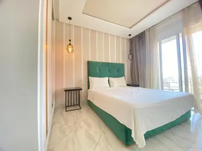 a bedroom with a large bed with a green headboard at Modern Family Home Ful Equipped in Oulad Akkou