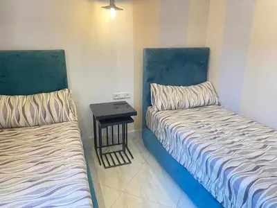 two beds in a room with a side table at Modern Family Home Ful Equipped in Oulad Akkou