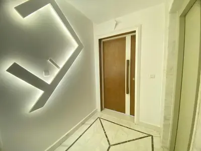 a hallway with a door and a wall with a light at Modern Family Home Ful Equipped in Oulad Akkou