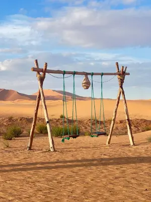 a swing in the middle of the desert at sunshine luxury camp in Merzouga