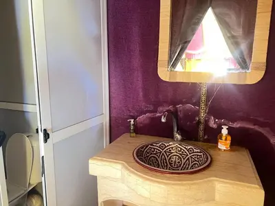 a bathroom with a sink and a purple wall at sunshine luxury camp in Merzouga