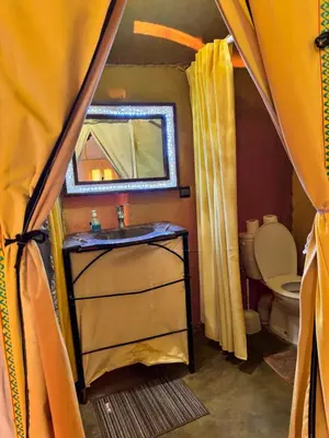 a bathroom with a sink and a mirror and a toilet at sunshine luxury camp in Merzouga