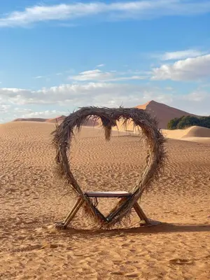 a wooden heart shaped chair in the desert at sunshine luxury camp in Merzouga