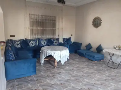 a living room with blue couches and a table at charmante villa à découvrir in Aghmat